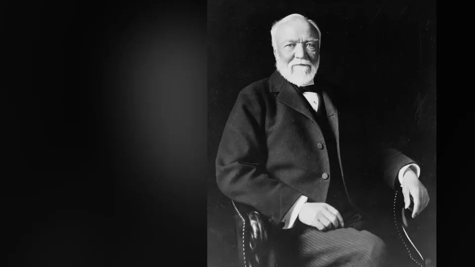 Retrato fotográfico de Andrew Carnegie, sentado y con traje oscuro, en 1913. Fotografía de Theodore C. Marceau, en dominio público; el fondo es una versión desenfocada de la misma imagen.